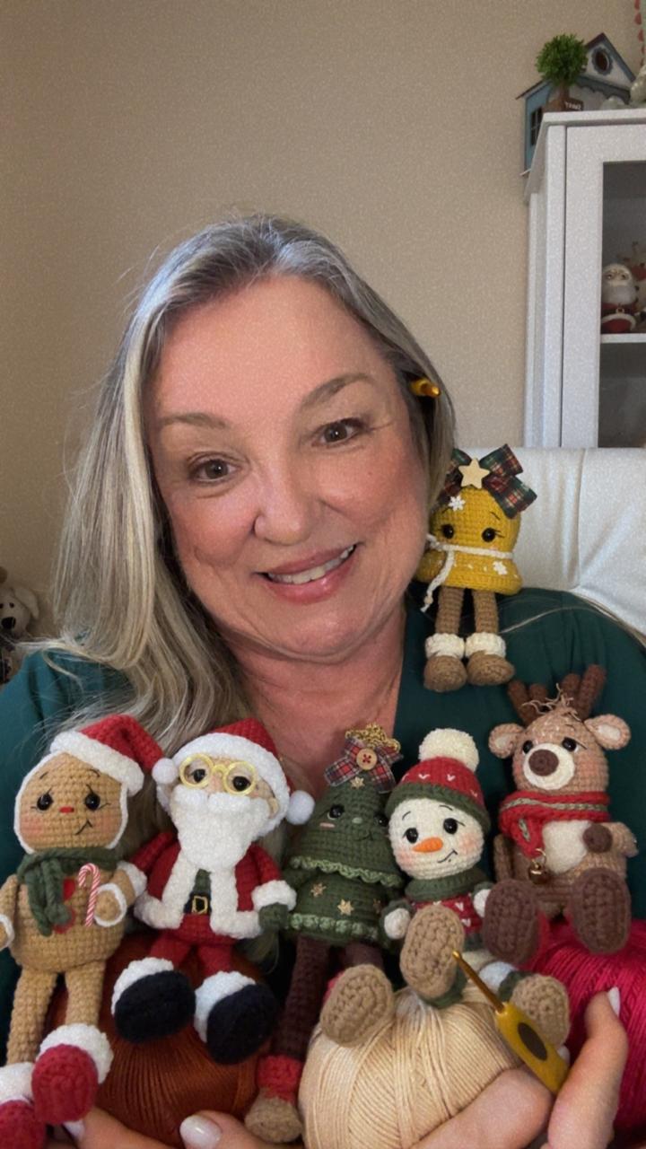 Rô sorrindo com os amigurumis de Natal nas mãos